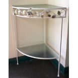 A mid 20th century white-painted metal corner table with glass top, shelf under, with floral and