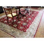 A Middle Eastern-style red-ground drawing room carpet with floral and foliate depictions with a