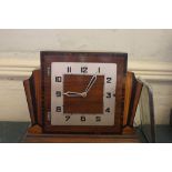 An Art Deco mantle clock with multiple wood inlay effect to the front, Arabic numerals, as found