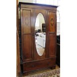 An Edwardian mahogany and cross banded wardrobe with shaped plinth, single oval shaped mirrored