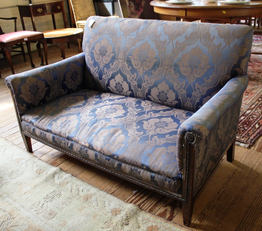 An Edwardian mahogany framed two seat settee with floral design fabric upholstery, shaped arms,