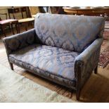 An Edwardian mahogany framed two seat settee with floral design fabric upholstery, shaped arms,
