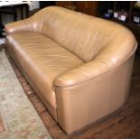 A contemporary light brown leather upholstered sofa with shaped arm rests, 190cm wide