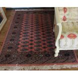 A Middle Eastern-style pink-ground hand knotted wool rug with double border and multicoloured