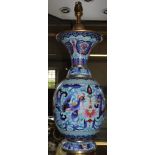 An Oriental cloisonne lamp stand with multicoloured floral and foliate depictions with gold rims,