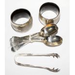 A pair of silver napkin rings, five silver teaspoons and a pair of silver sugar tongs (3)