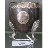 A silver mounted half coconut cup raised on three lion paw feet, as found