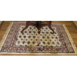 A Middle Eastern-style ivory-ground drawing room rug with multicoloured isometric and lozenge-