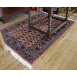 A Middle Eastern-style pink-ground hand knotted wool rug with double border and multicoloured