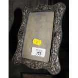 A silver photo frame decorated in relief, 7" x 5", Birmingham 1909