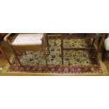 An ivory-ground Kashmir-style red-ground floor rug with multicoloured floral design with long
