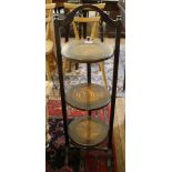 An early 20th century oak-stained adjustable cake stand with circular plates on trestle supports