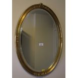 An oval gilt framed wall mirror with bevelled plate, 66cm x 45cm