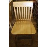 A set of four hardwood contemporary dining chairs with shaped top rails, spindle supports, raised on