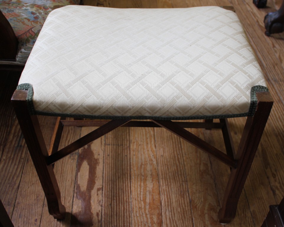 An early 20th century oak framed oblong dressing stool with upholstered seat and stretcher supports