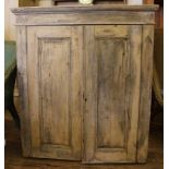 An antique stripped pine hanging wall unit of oblong form with shaped cornice, plain frieze,