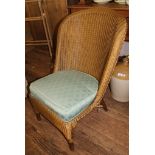 A Lloyd Loom-style mid 20th century gold painted wicker chair with removable cushion on circular