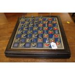 A lacquered framed chess set with figured leaded pieces