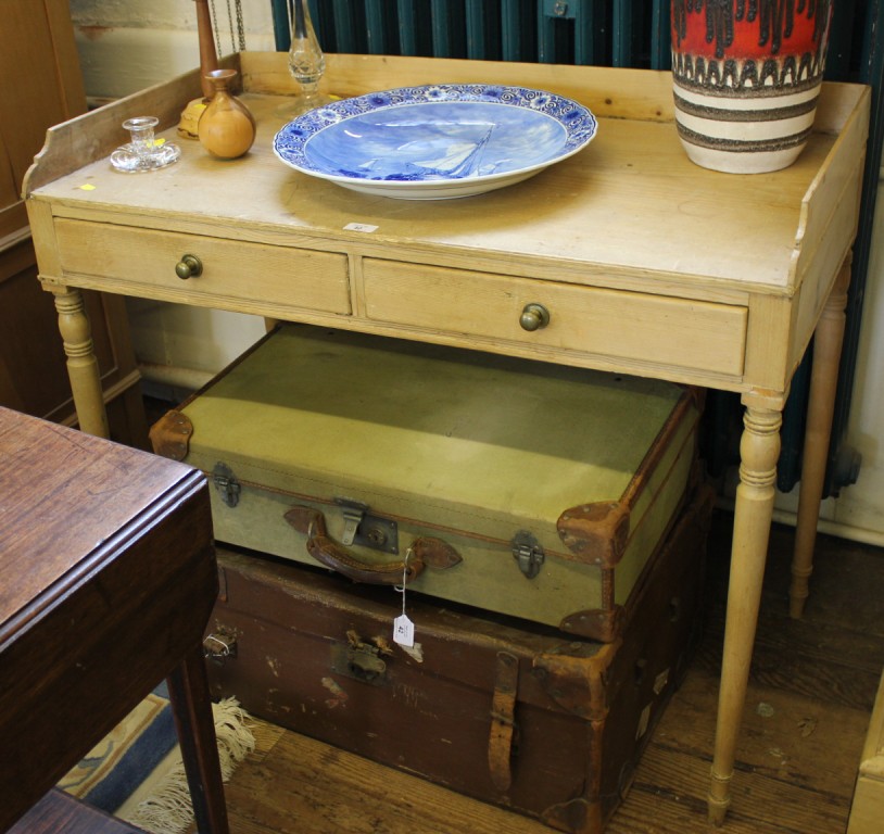 An early 19th century pine writing table with 3/4 gallery, two drawers under with circular brass