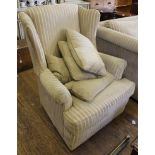 A contemporary fabric upholstered wood-framed wingback armchair with removable cushions, 82cm wide
