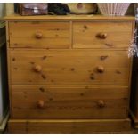 A pine chest of two small and two long drawers with shaped top, circular handles on plinth, 88H x