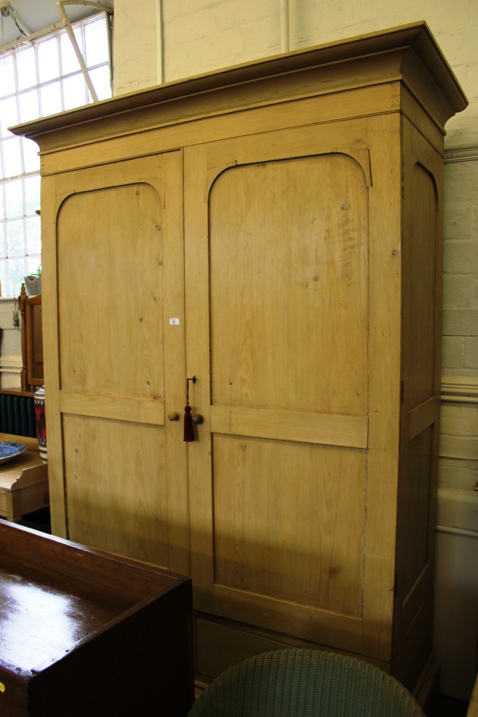 A Victorian waxed pine double wardrobe with shaped cornice, plain frieze, double panelled doors,