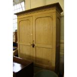 A Victorian waxed pine double wardrobe with shaped cornice, plain frieze, double panelled doors,