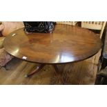 A Regency-style oval mahogany and cross banded coffee table with ebony inlay to the top, raised on a