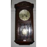 An early 20th century oak stained wall clock by MacKenzie, circular dial with Arabic numerals,