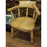 A beech wood child's chair with carved top rail and arm rests, spindle supports, dished on turned