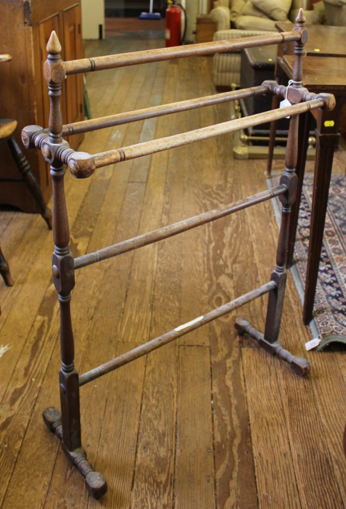 An Edwardian stained pine towel holder on trestle supports