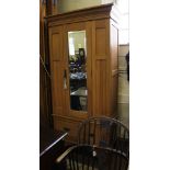 An Art Nouveau satin wood single wardrobe with shaped cornice, mirrored door, interior fitted for