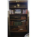 An Art Deco stained pine free standing bookcase with stylised carving to the frieze, six shelves,