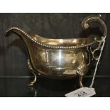 A silver sauce boat on three hoof feet with beaded edge. Condition: marks rubbed, some slight dents,