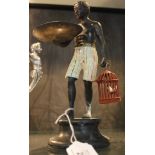 A bronzed figurine of a man holding a copper plate with basket on socle with hand painted