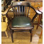 An early 20th century elm-stained office chair with shaped top rail, carved arm rests, spindle