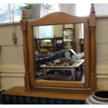 A contemporary pine vanity mirror with oblong plate, twin turned supports on a platform base