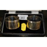 A pair of silver napkin rings in presentation box, together with a pair of brandy glasses with