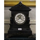 A 19th century slate mantle clock with arched cornice, incised and applied carving to the cornice