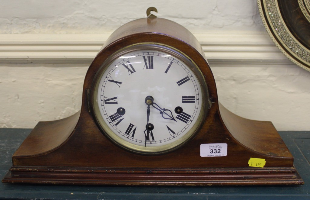 An Edwardian mahogany dome-shaped mantle clock with Roman numerals raised on a stepped base