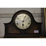 An early 20th century oak-stained dome-top mantle clock, circular dial, Arabic numerals, rope