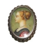 A silver brooch pendant with a miniature portrait of a young woman with artist initials B.I.