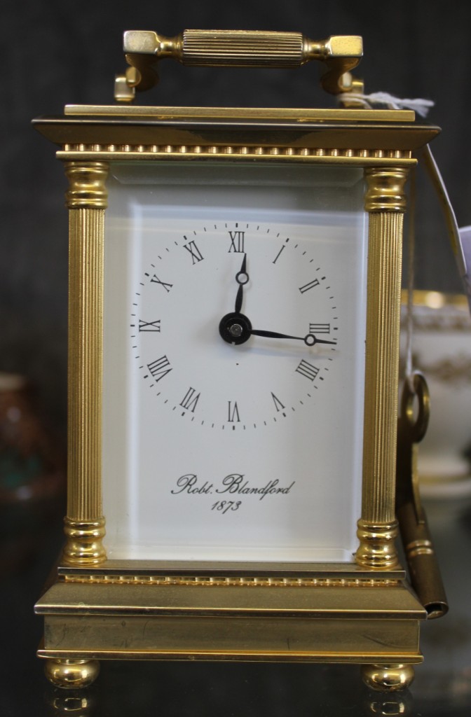 A brass French carriage clock by Robert Blandford, 1873 with Roman numerals and swing handle in