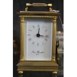 A brass French carriage clock by Robert Blandford, 1873 with Roman numerals and swing handle in