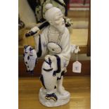 A ceramic figurine of a Chinese fisherman on a stylized base, 37cm high