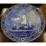 A hand painted blue and white Delft charger with fishing pinks unloading catch on seashore after