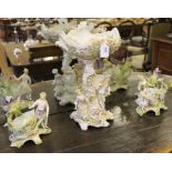 A 19th century Meissen-style ceramic table centre, raised on a stylized figurines and base with a