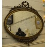 A 19th century oval gilt framed wall mirror with ribbon floral and foliate carved applied