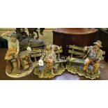 Three Capodimonte figurines, two of gentlemen seated on benches and one cobbler on stylized bases
