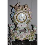 A 19th century Meissen-style porcelain elaborately carved and decorated mantle clock surmounted by a